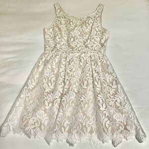 White lace dress with nude underlay.